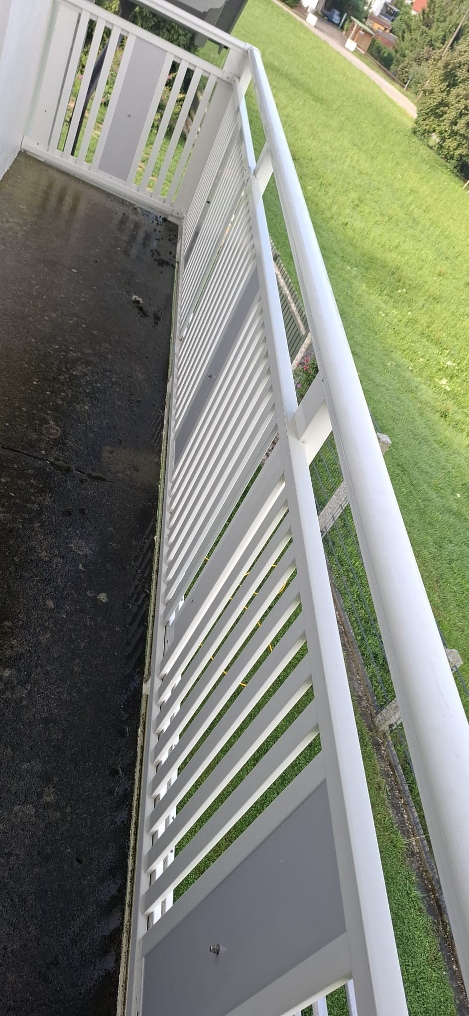 Gereinigter Terrasse mit Steinboden und weißem Terrassengeländer.